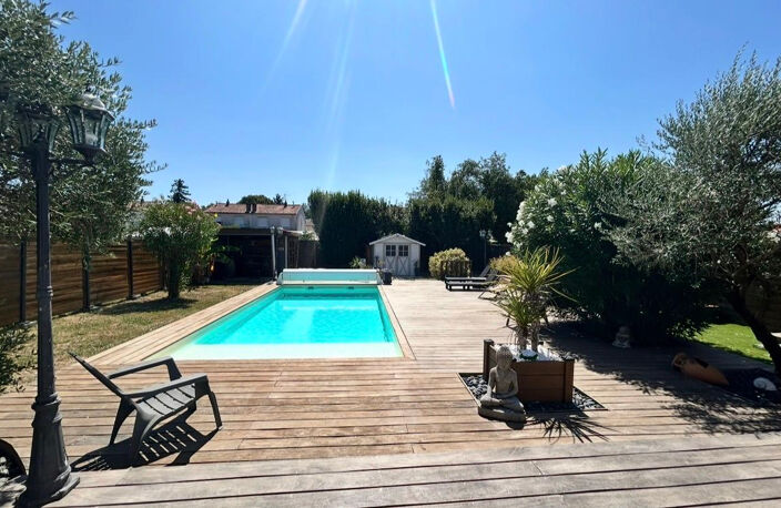 Ambès - Maison de 82 m2 habitables sur un terrain clos d'environ 596 m2- Piscine chauffée- Terrasse en bois exotique 100 m² -Pool house-Patio cosy-Garage-Stationnement extérieur - Boulodrome - Espace Barbecue — photo 2