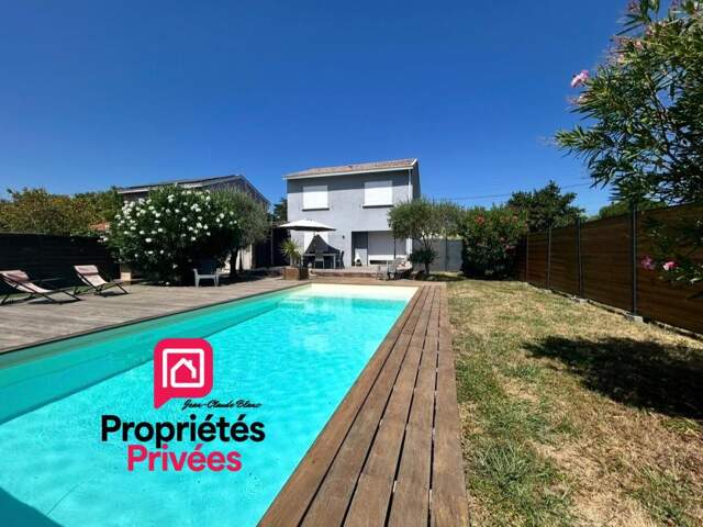 Ambès - Maison de 82 m2 habitables sur un terrain clos d'environ 596 m2- Piscine chauffée- Terrasse en bois exotique 100 m² -Pool house-Patio cosy-Garage-Stationnement extérieur - Boulodrome - Espace Barbecue — photo du bien