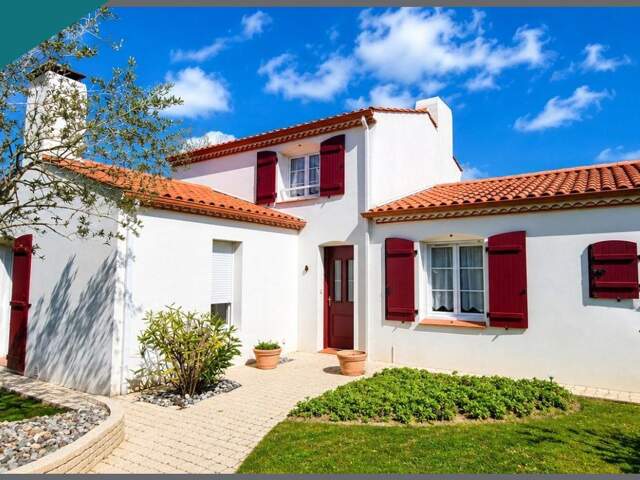 Maison familiale avec vie de plain-pied, double garage et jardin paysagé — photo du bien