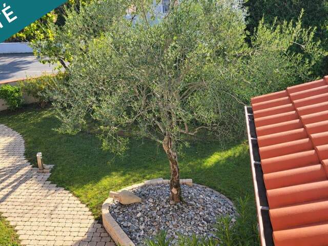 Maison familiale avec vie de plain-pied, double garage et jardin paysagé — photo du bien
